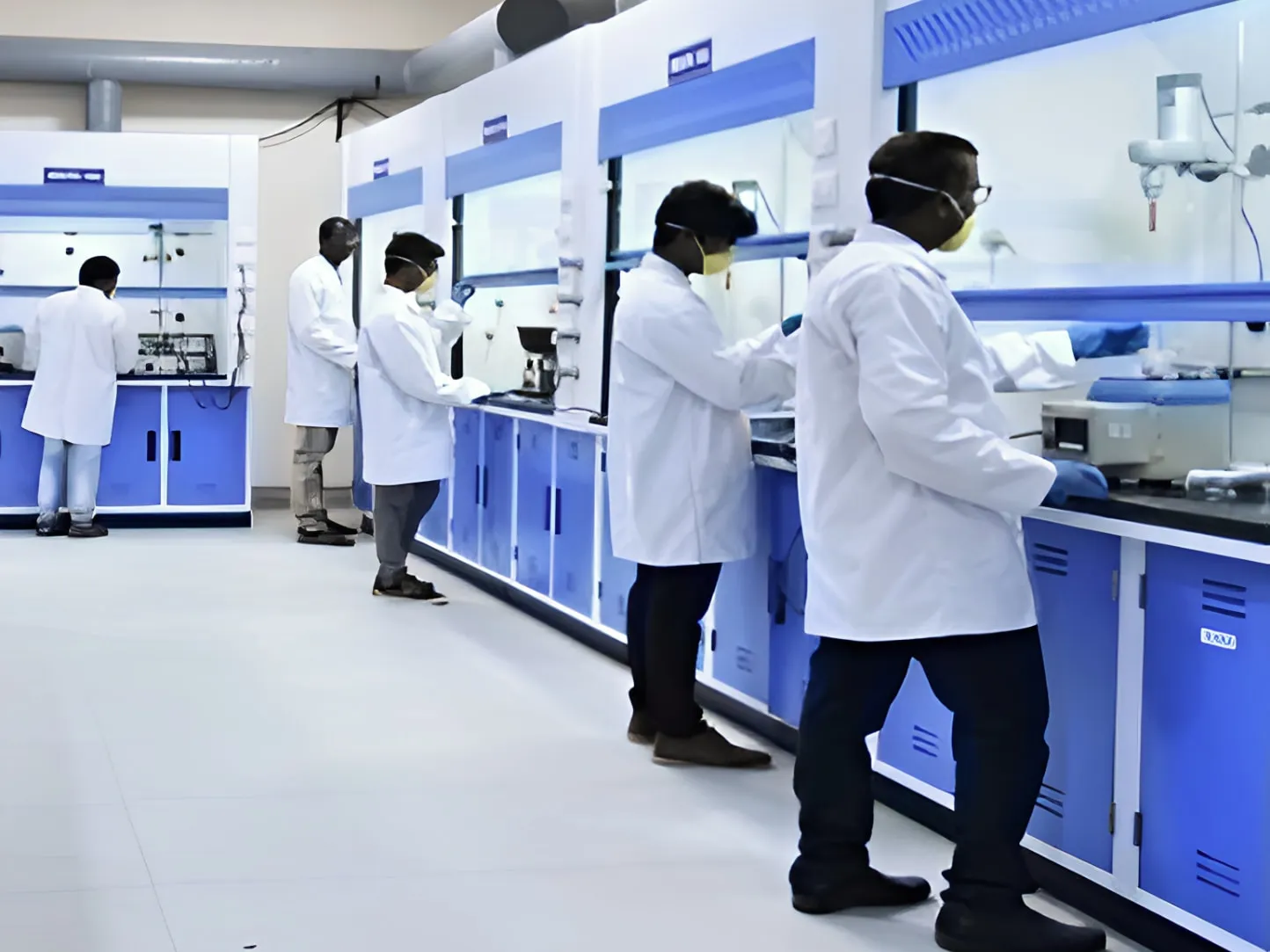 Chemists working at fume hoods in the VSRA Life Sciences research laboratory